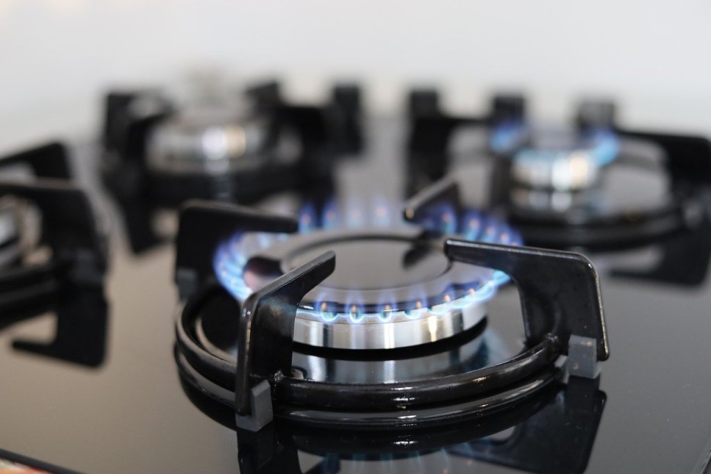 Black gas stove top with blue flames