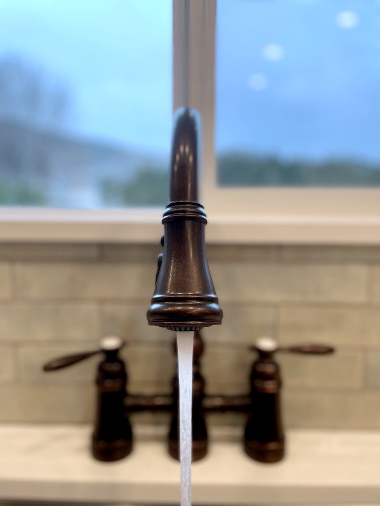 plumbers in kamloops test a kitchen faucet after working on kitchen plumbing installation for a new home